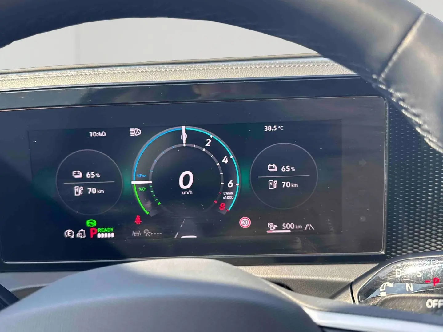 Vue rapprochée du tableau de bord numérique du Volkswagen Tiguan gris, affichant les indicateurs de vitesse et batterie.