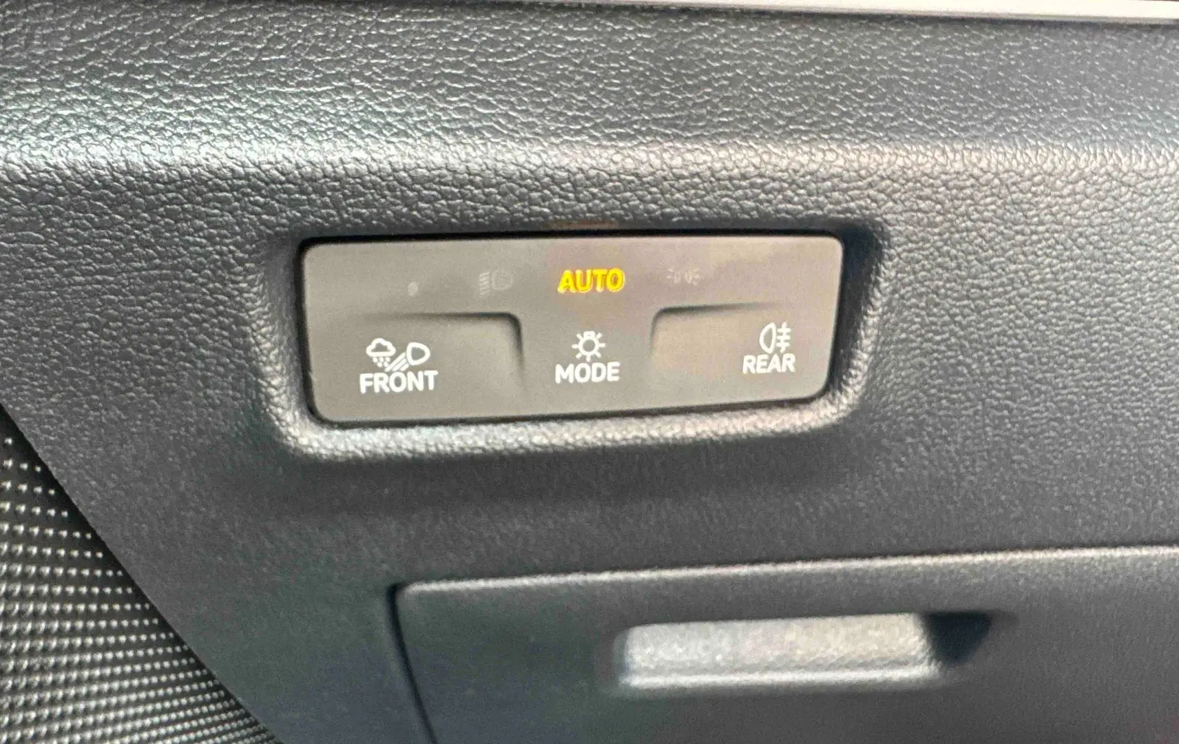 Détail du tableau de bord noir du Volkswagen Tiguan 2025 montrant les commandes d’éclairage automatiques.