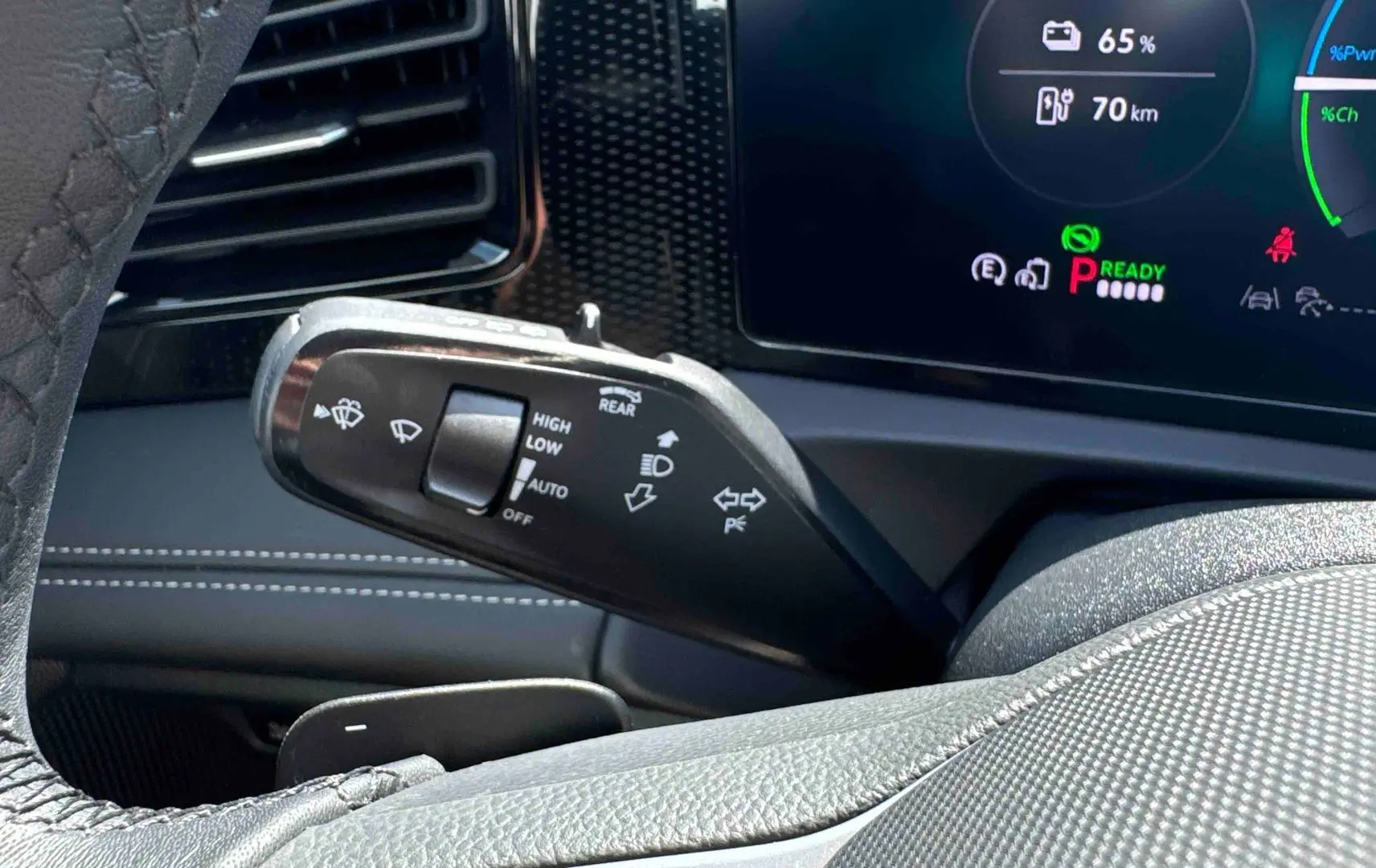 Gros plan sur la manette de commandes du volant dans l’habitacle gris du Volkswagen Tiguan eHybrid 2025.