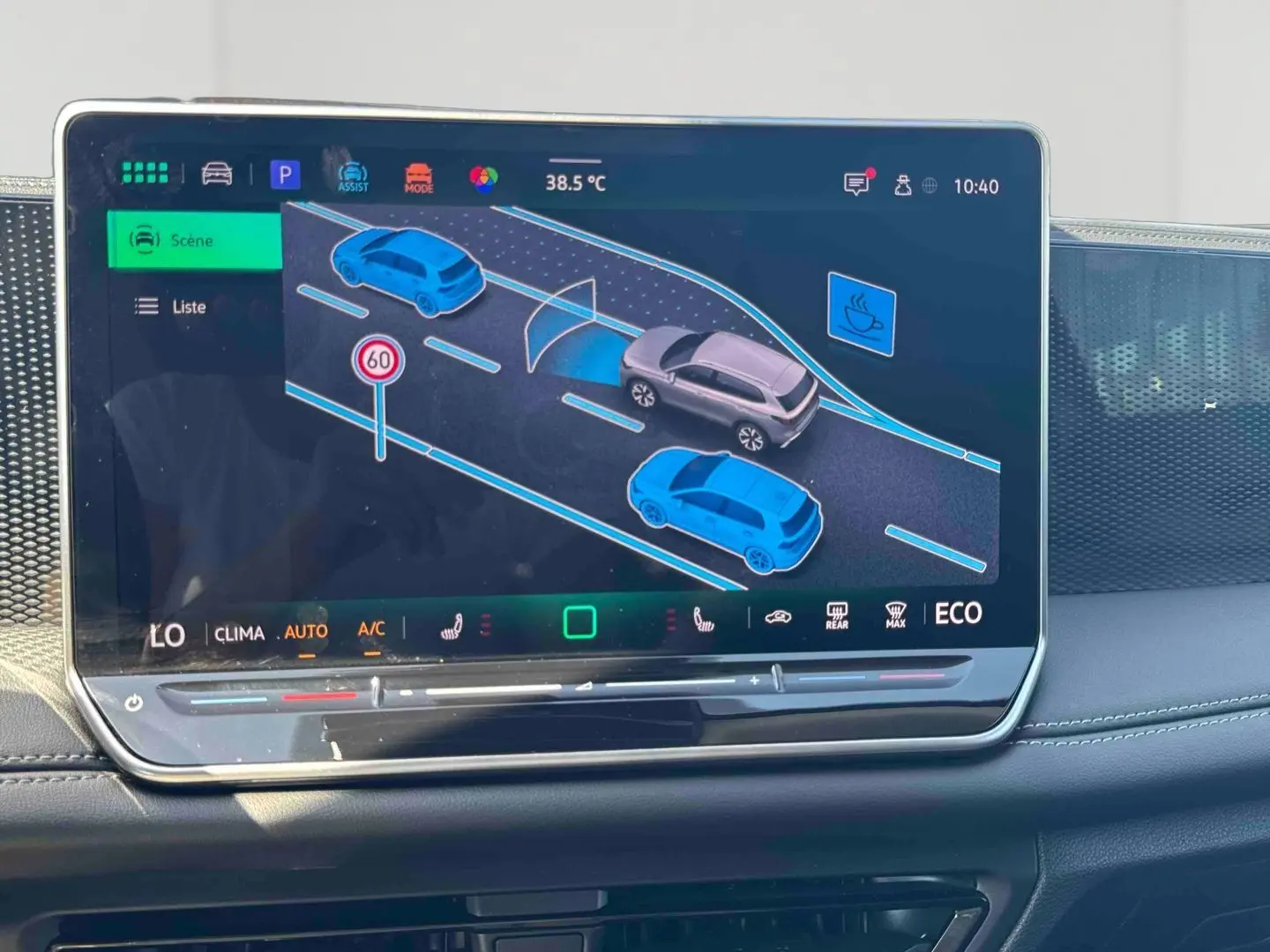 Écran tactile intérieur du Volkswagen Tiguan 2025 montrant l'assistance à la conduite avec affichage de la route et véhicules.