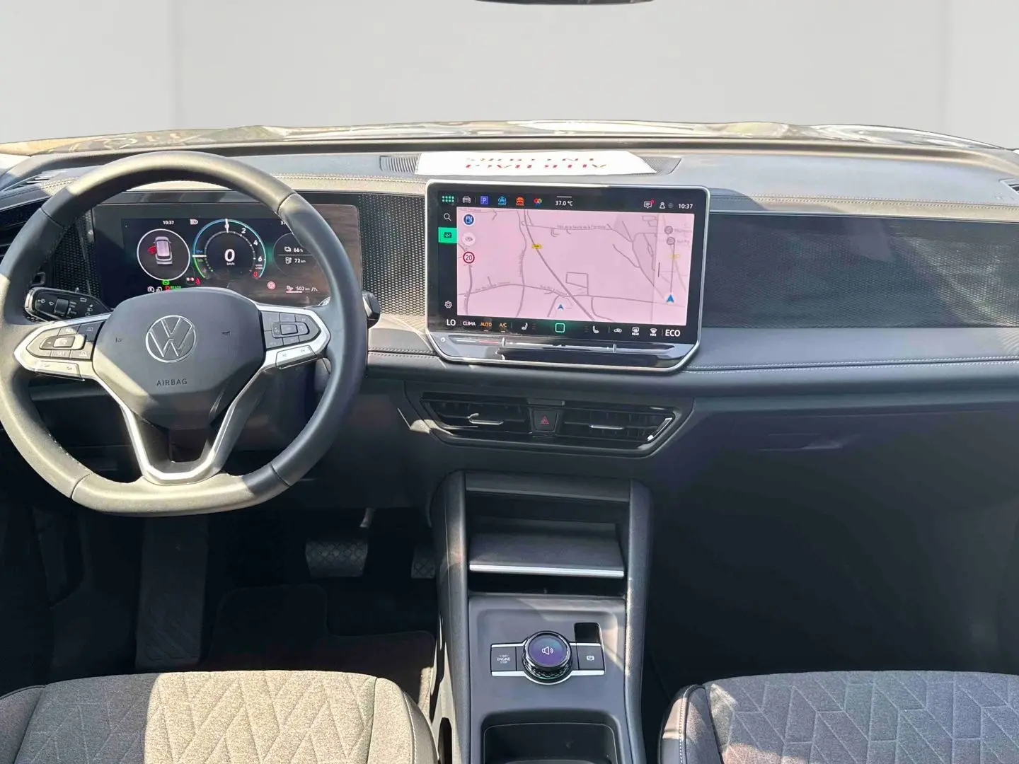 Vue intérieure frontale du tableau de bord du Volkswagen Tiguan 2025 avec écran tactile central et volant multifonction noir.