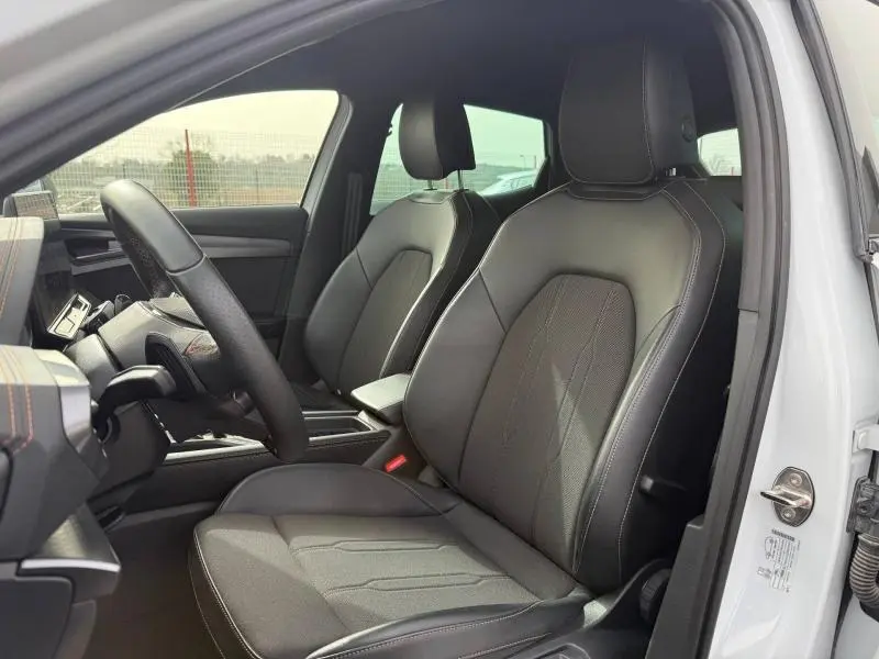 Vue intérieure côté conducteur de la CUPRA Formentor blanc Nevada, sièges en cuir noir avec surpiqûres contrastées.