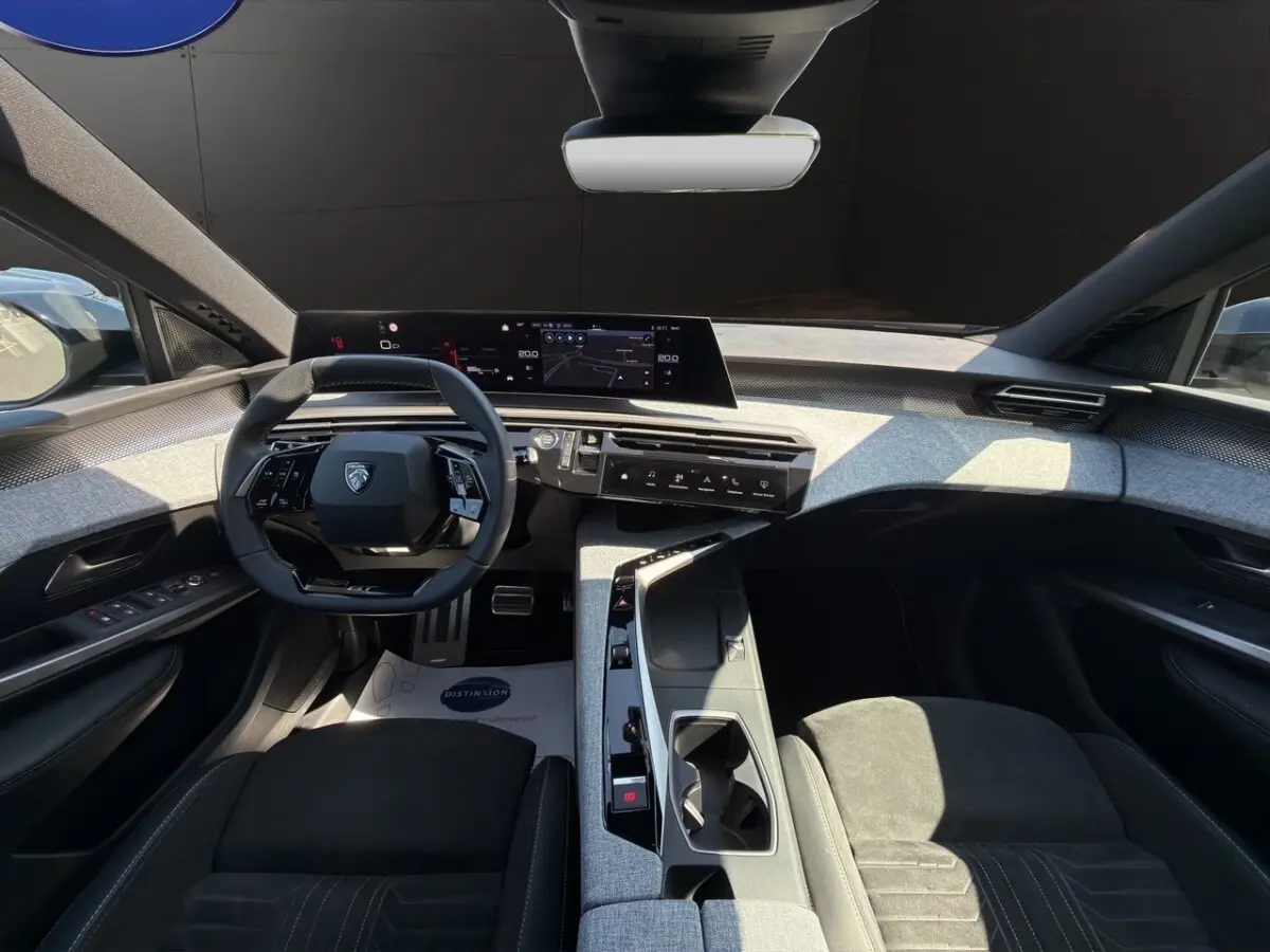 Intérieur Peugeot 5008 2025 vu de face, tableau de bord numérique large et sellerie Alcantara noire.