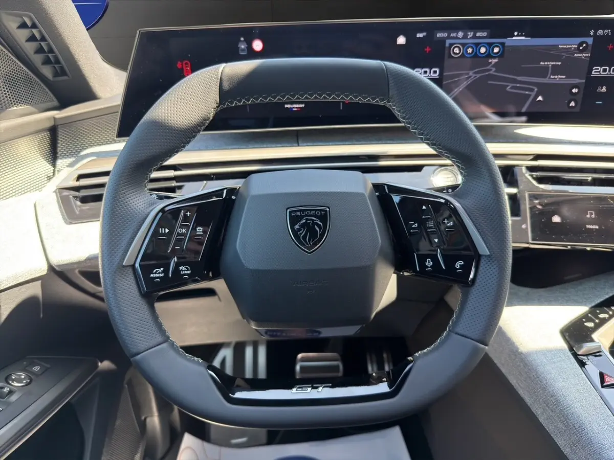 Vue rapprochée du volant cuir noir GT de la Peugeot 5008 2025 avec commandes multifonctions et tableau de bord numérique.