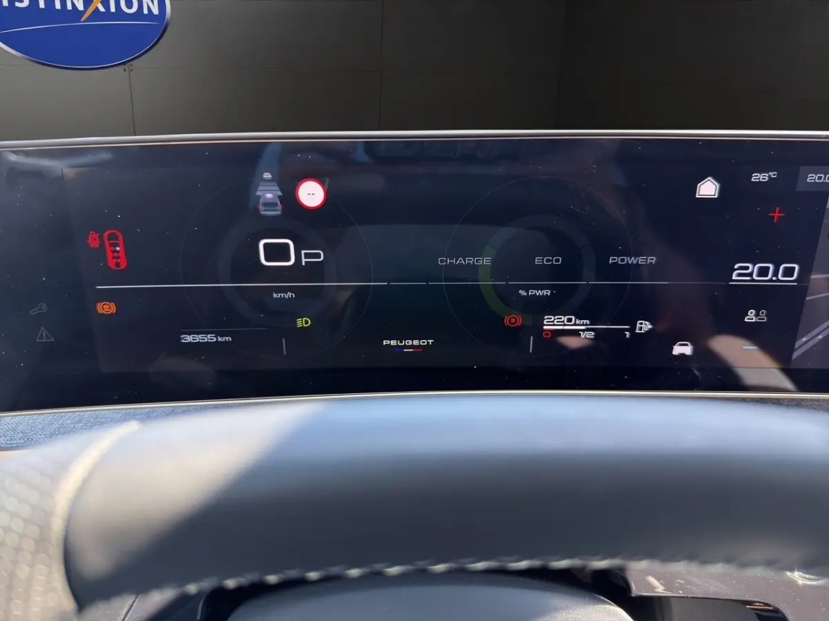 Tableau de bord numérique du Peugeot 5008 hybride 2025 affichant vitesse, autonomie et indicateurs, vue frontale rapprochée.