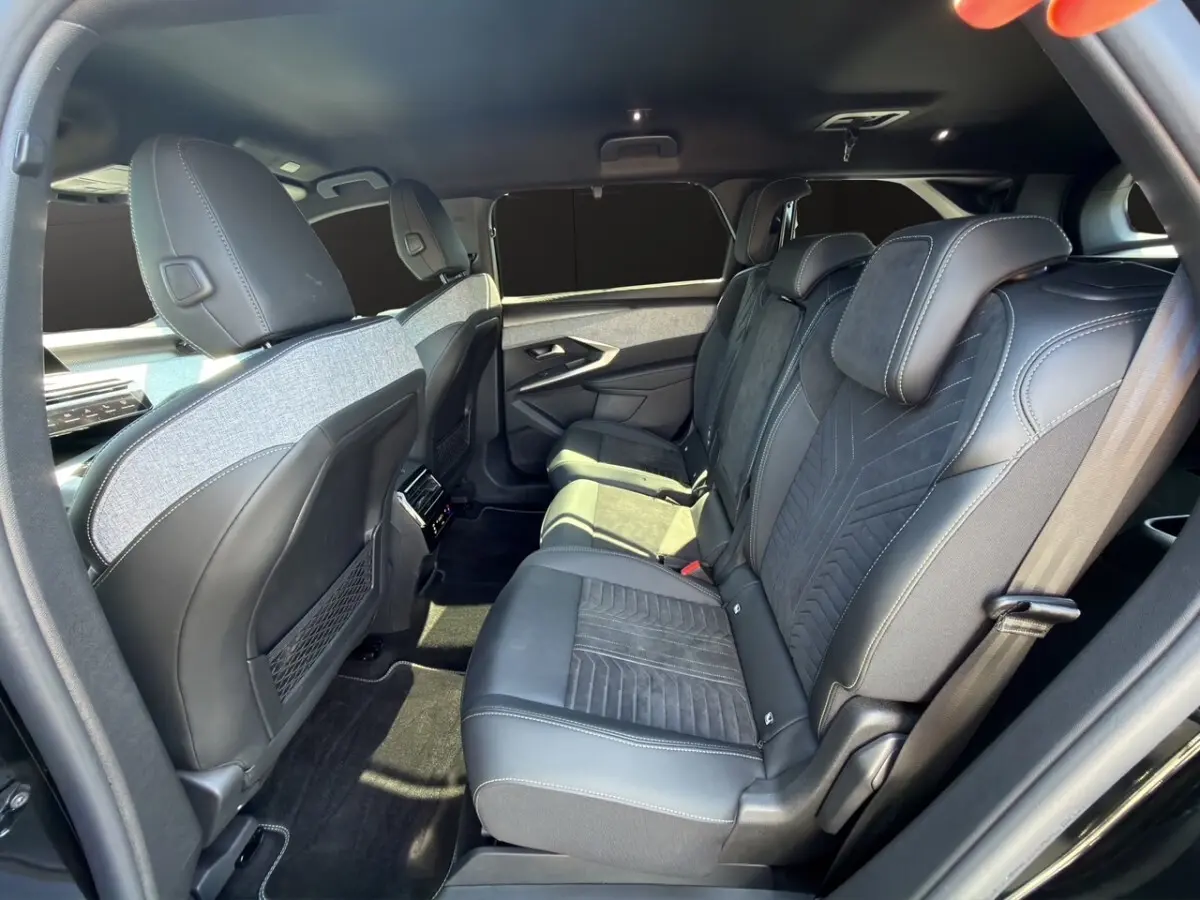 Vue latérale intérieure côté droit montrant les sièges arrière en cuir et alcantara du Peugeot 5008 noir 2025.