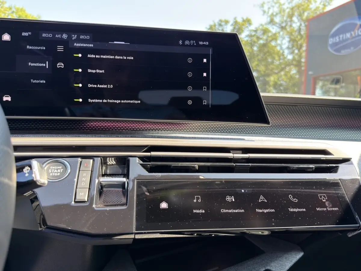 Vue intérieure du tableau de bord du Peugeot 5008 2025, avec écran tactile central et commandes digitales noires.