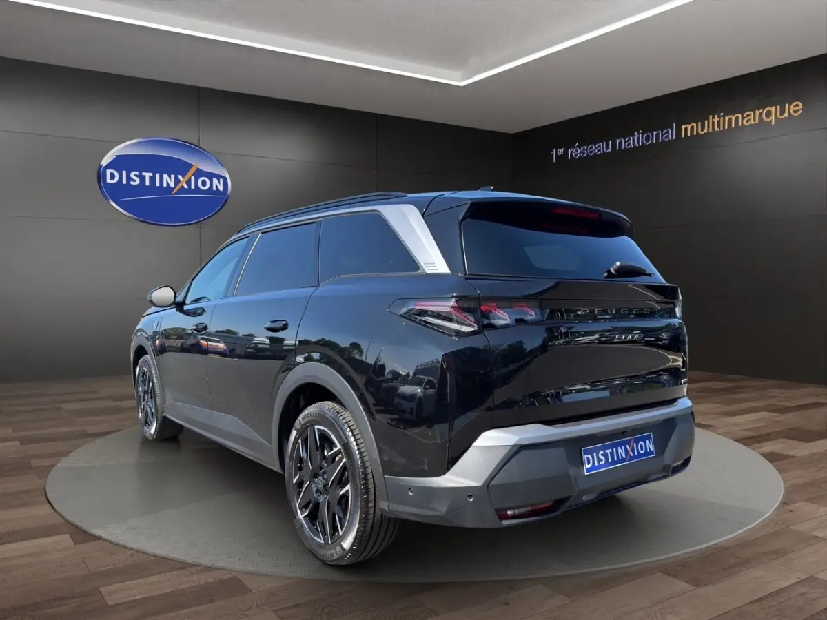 Peugeot 5008 noir en 3/4 arrière droit, avec jantes noires et détails argentés sur le toit et le bouclier.