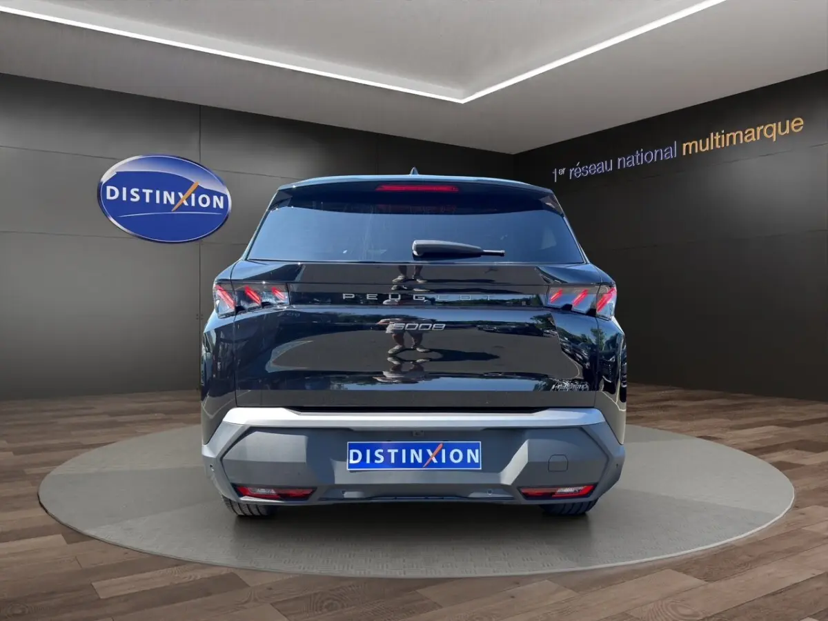 Vue arrière du Peugeot 5008 noir 2025 avec feux LED et logo distinctif sur fond showroom.