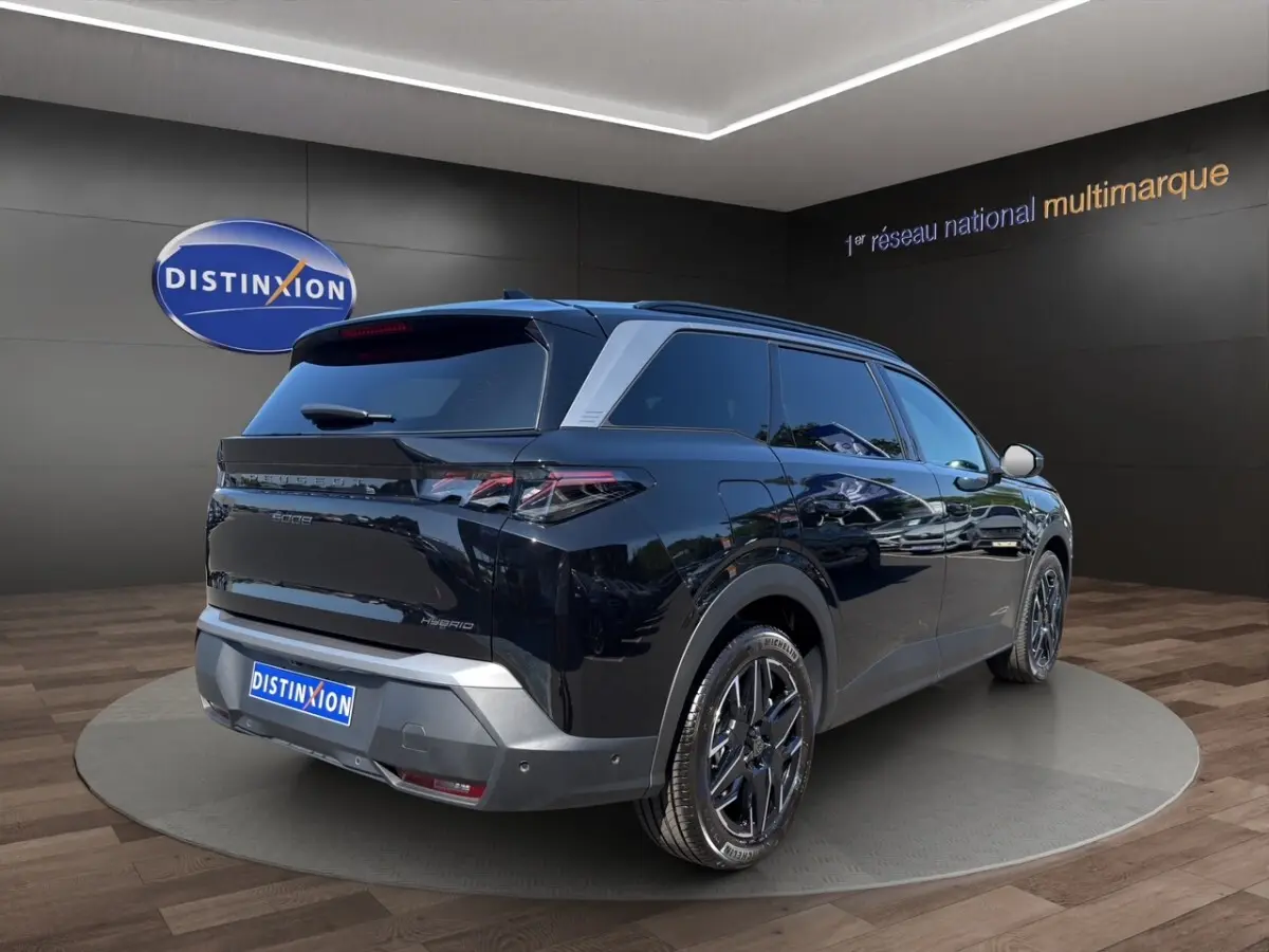 Peugeot 5008 noir vue 3/4 arrière droit, avec jantes alliage noires et vitres teintées en showroom.