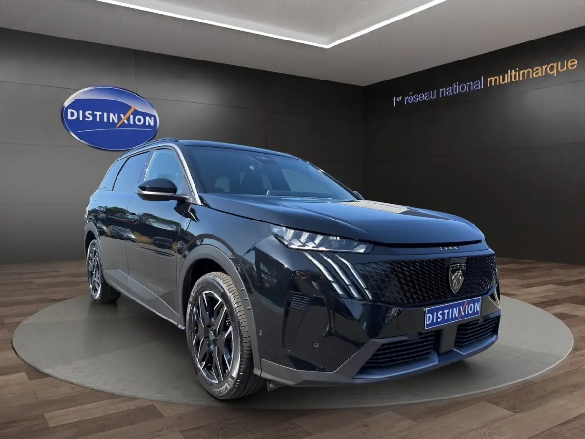Peugeot 5008 noir en 3/4 avant droit, avec calandre noire distinctive et jantes alliage foncé.