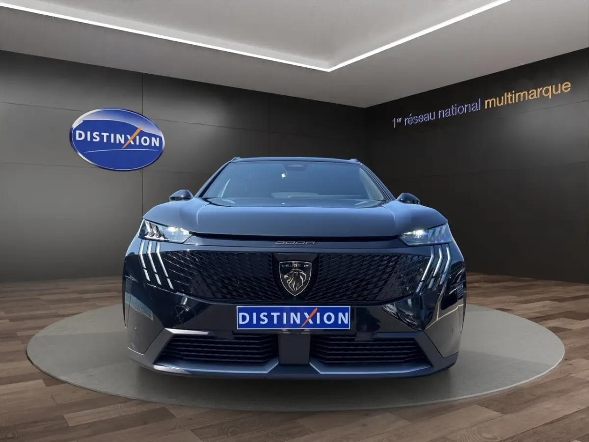 Vue frontale d’un Peugeot 5008 noir avec calandre distinctive et feux LED en forme de griffes.