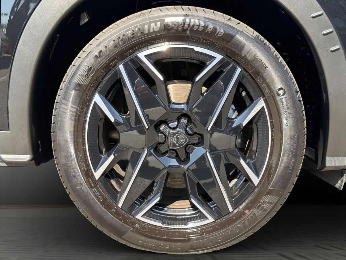 Gros plan sur la roue avant droite noire avec jante Peugeot 5008 1.2 Hybrid 145 GT 2025.