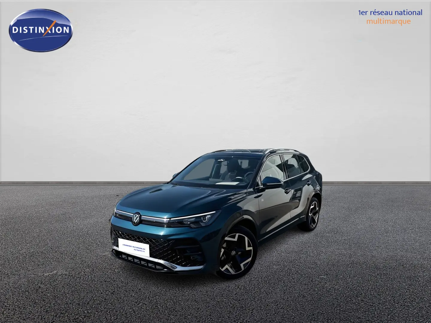 Volkswagen Tiguan 2025 bleu en 3/4 avant droit avec jantes alliage et toit ouvrant panoramique visible.