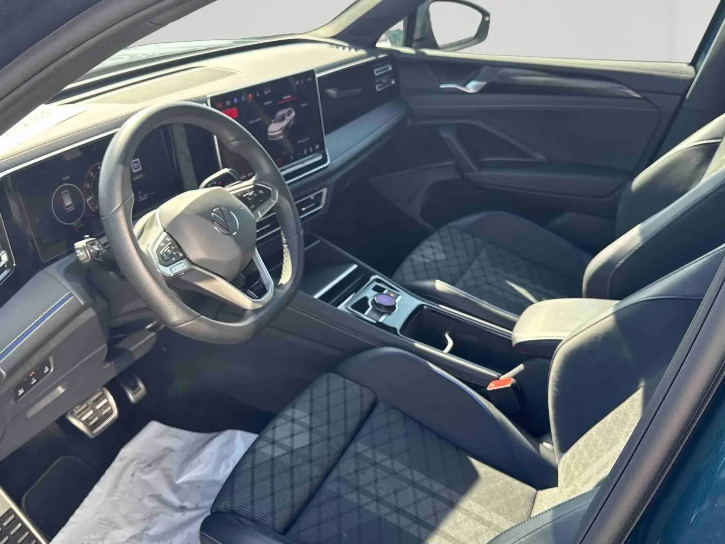 Vue intérieure côté conducteur du Volkswagen Tiguan 2025 avec sièges sport en cuir et tableau de bord numérique.