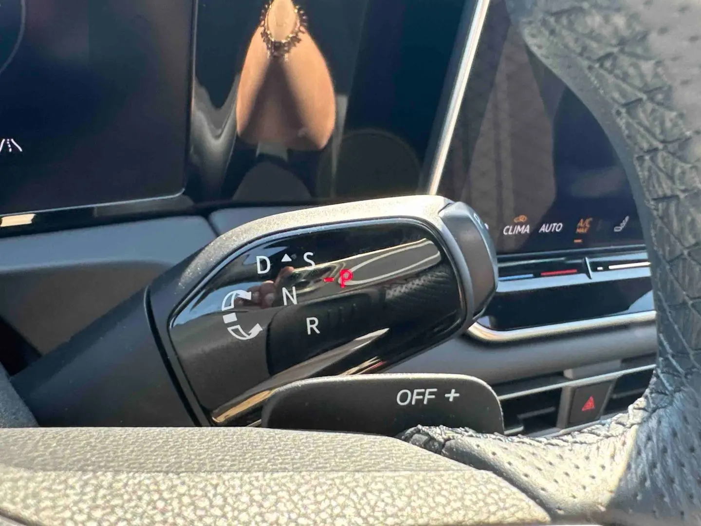 Levier de boîte manuelle noir vu de près dans l'habitacle du Volkswagen Tiguan 2025, avec affichage digital en arrière-plan.
