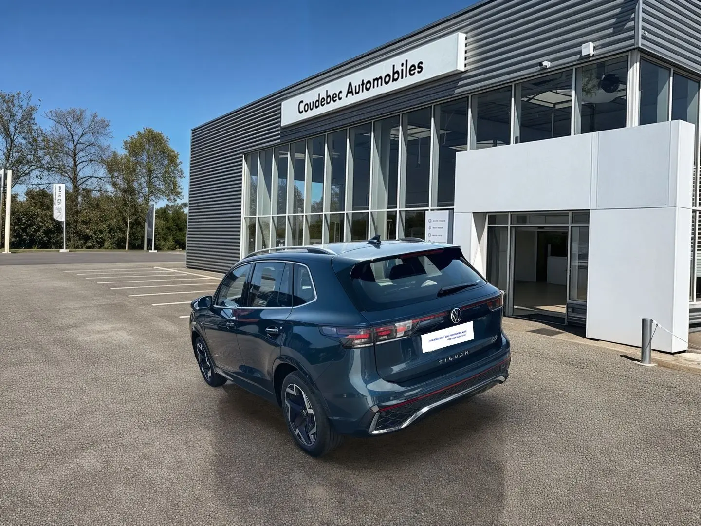 Vue 3/4 arrière droite du Volkswagen Tiguan bleu 2025, avec feux arrière LED 3D et jantes alliage 19 pouces visibles.