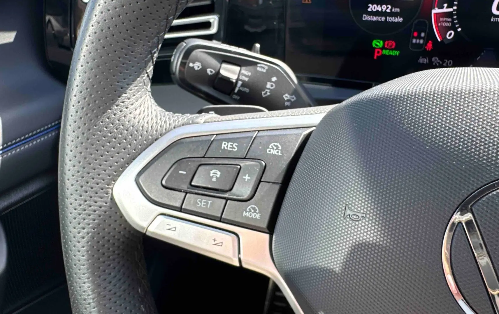 Gros plan sur le volant cuir perforé du Volkswagen Tiguan 2025 avec commandes multifonctions et tableau de bord digital.