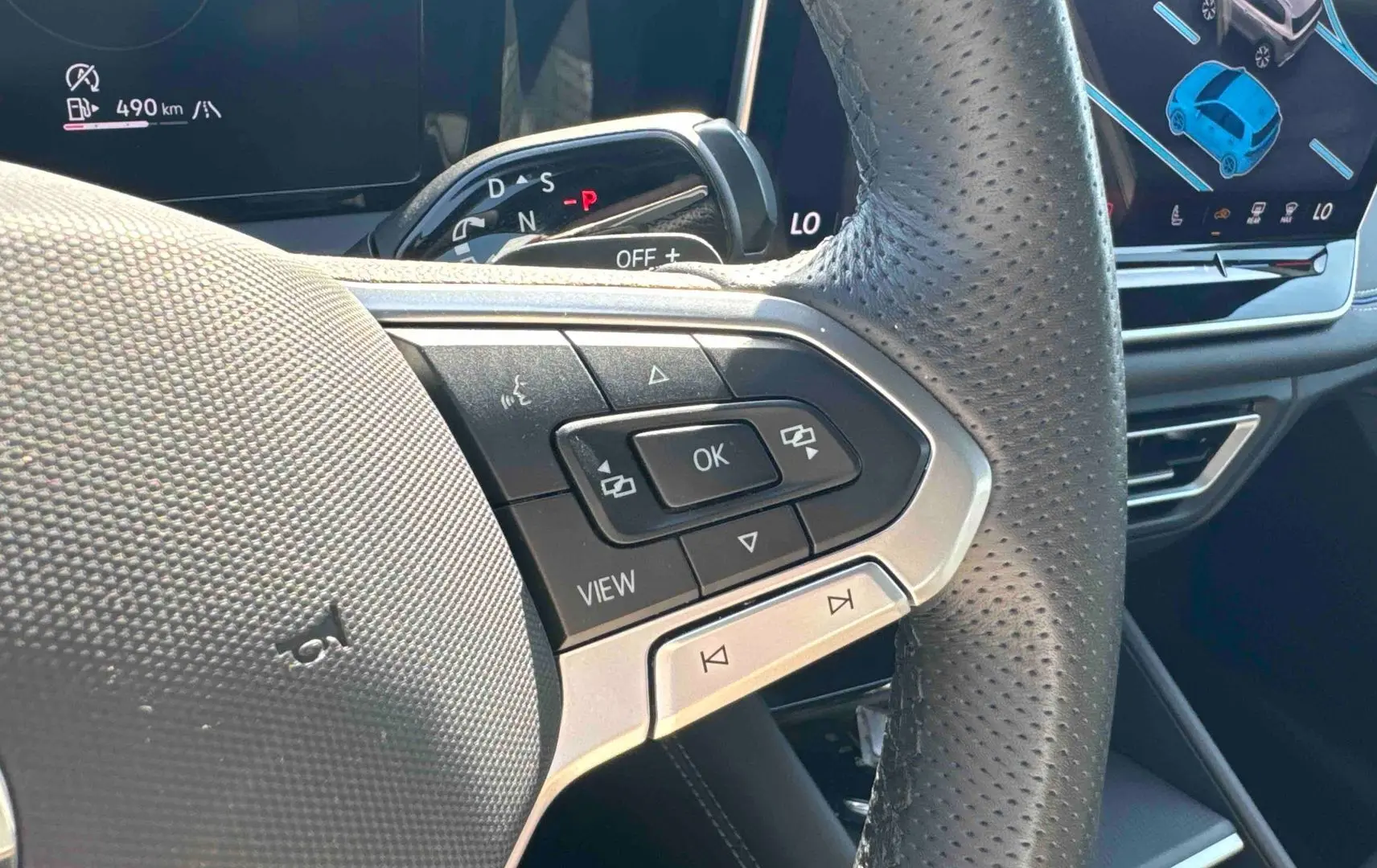Gros plan sur le volant cuir perforé et les commandes multifonctions du Volkswagen Tiguan 2025, intérieur noir.