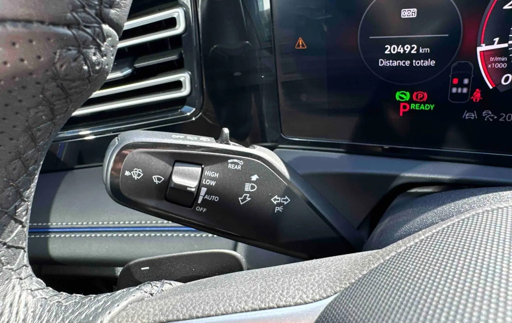 Gros plan sur la manette de commandes des essuie-glaces et clignotants dans l’habitacle du Volkswagen Tiguan 2025 bleu.