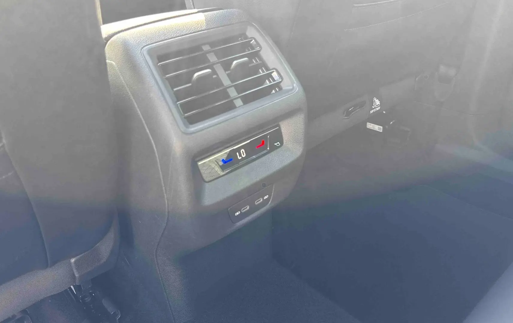 Détail de la console centrale arrière avec réglage climatisation et prises USB du Volkswagen Tiguan bleu 2025.