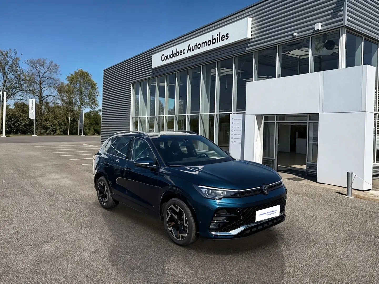 Volkswagen Tiguan 1.5 eTSI 150ch bleu, vue 3/4 avant droit devant concession Coudebec Automobiles.