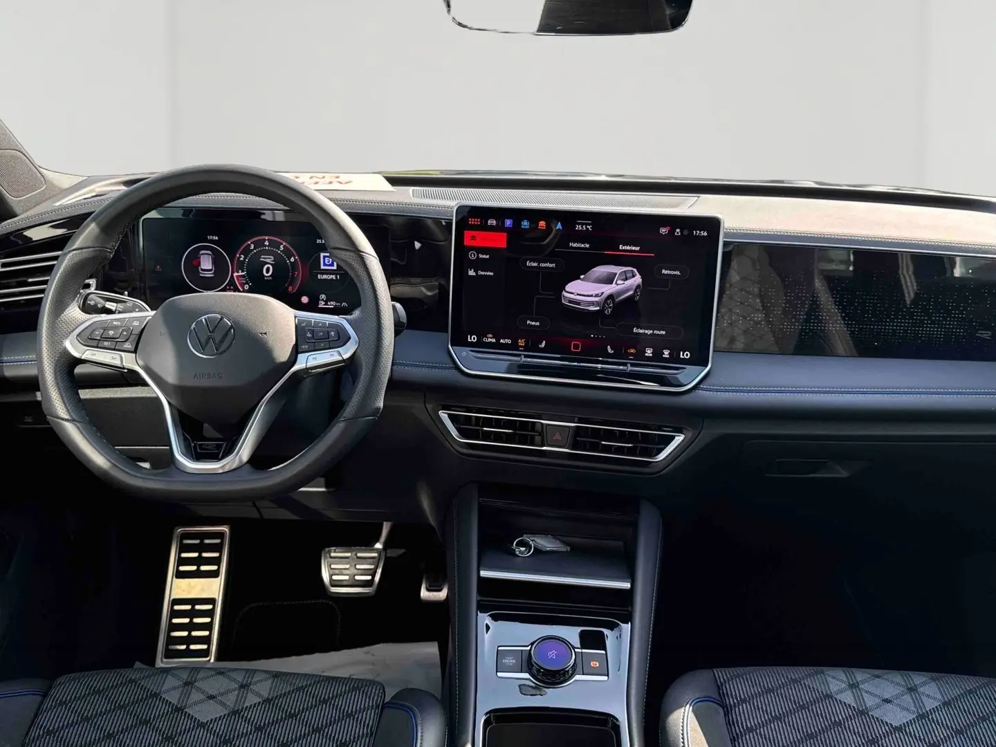 Vue intérieure frontale du Volkswagen Tiguan 2025 avec tableau de bord numérique et écran tactile central lumineux.