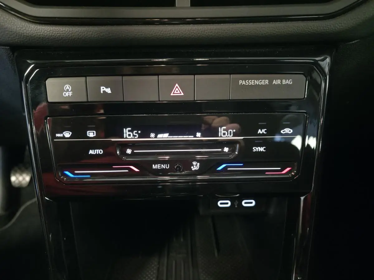 Vue rapprochée de la console centrale du Volkswagen T-Cross gris 2025, affichant la climatisation bi-zone et ports USB-C.