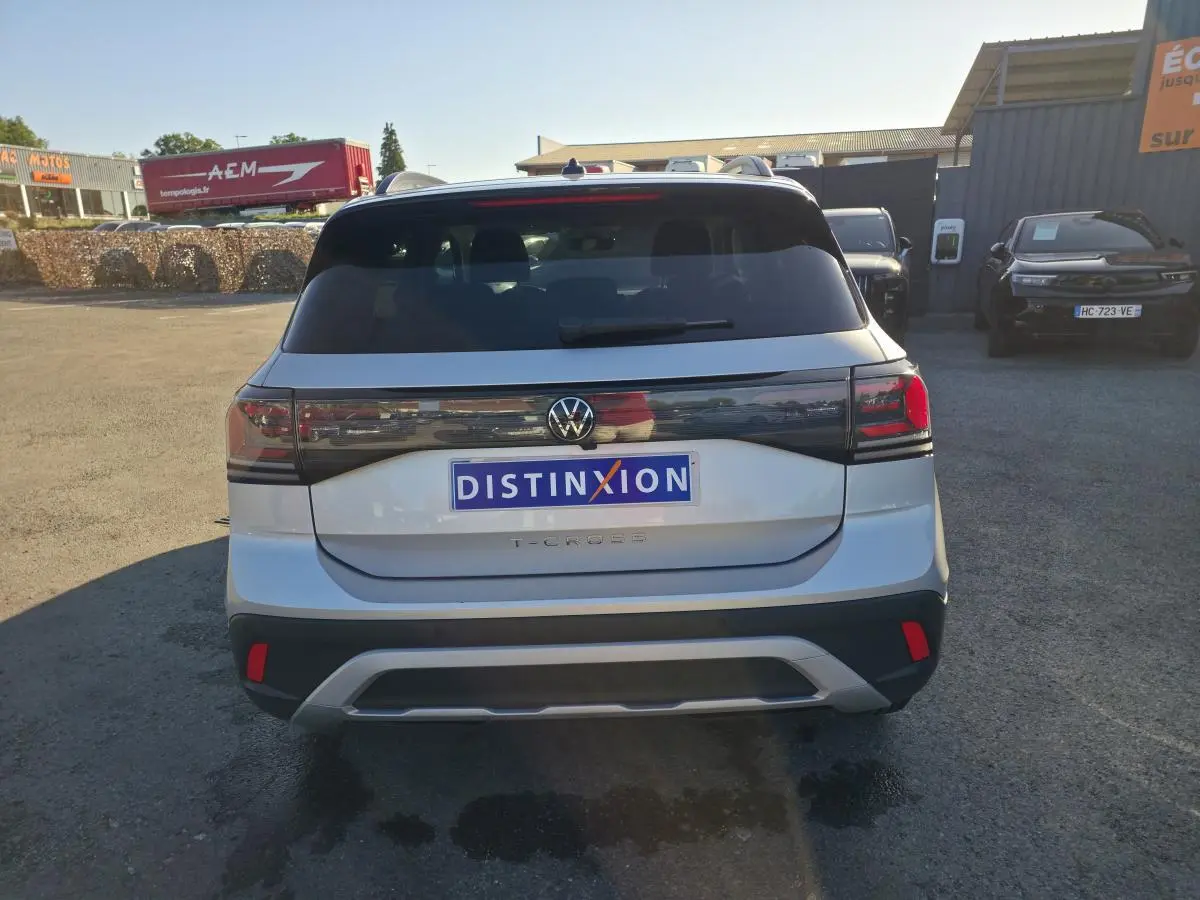 Vue arrière d'un Volkswagen T-Cross gris métallisé 2025 avec feux arrière LED et lunette teintée.