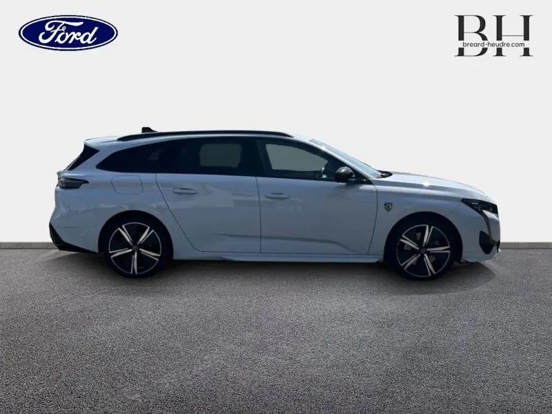 Peugeot 308 SW PHEV blanc Okénite vue de profil côté gauche avec jantes alliage noires et toit noir.