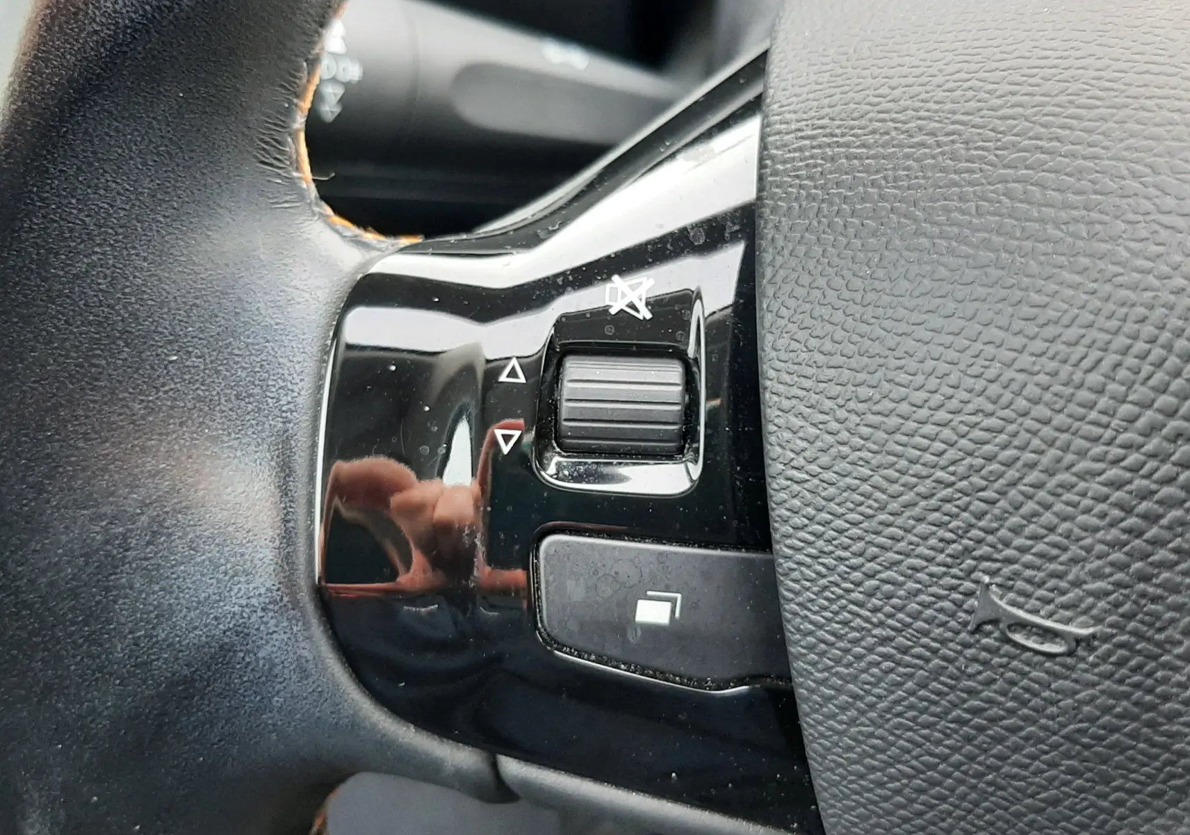 Gros plan sur les commandes noires du volant en cuir noir du Peugeot 308 SW Gris Artense, version 1.2 PureTech 110ch.