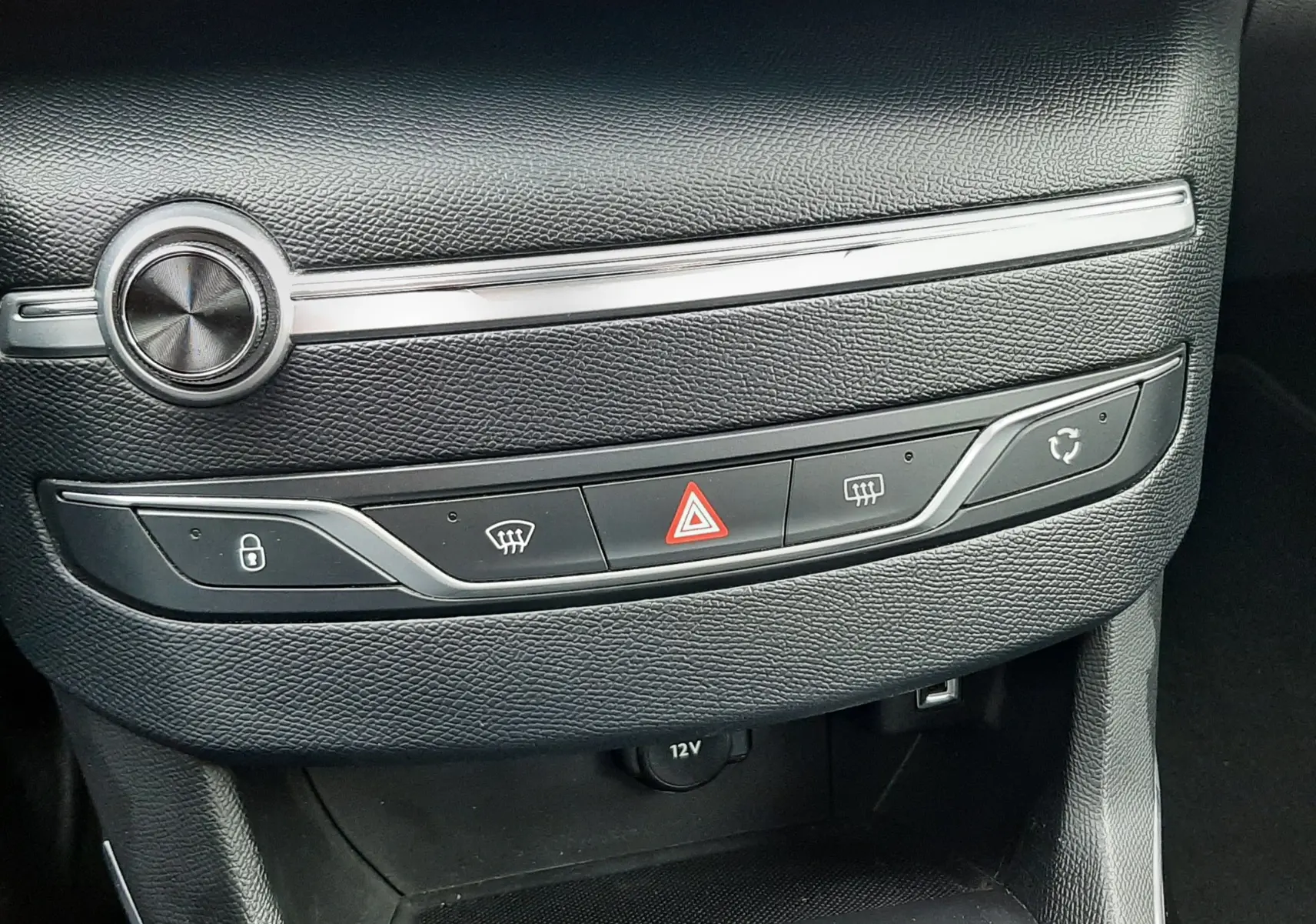 Détail de la console centrale noire du Peugeot 308 SW 2021, montrant les boutons de verrouillage, dégivrage et alerte hazard.