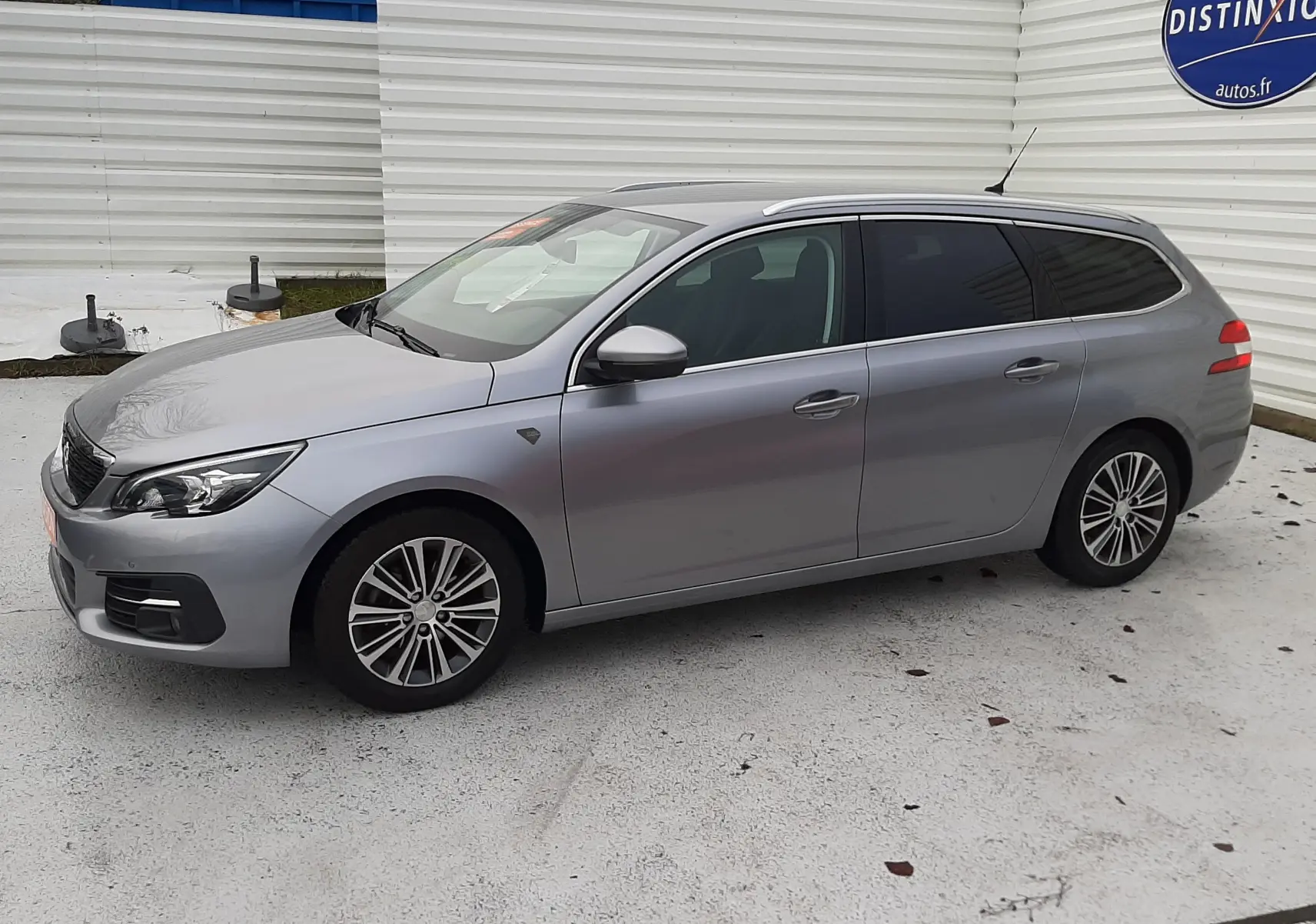 Peugeot 308 SW gris Artense vue de profil côté gauche, break 5 portes avec jantes alliage et vitres teintées.