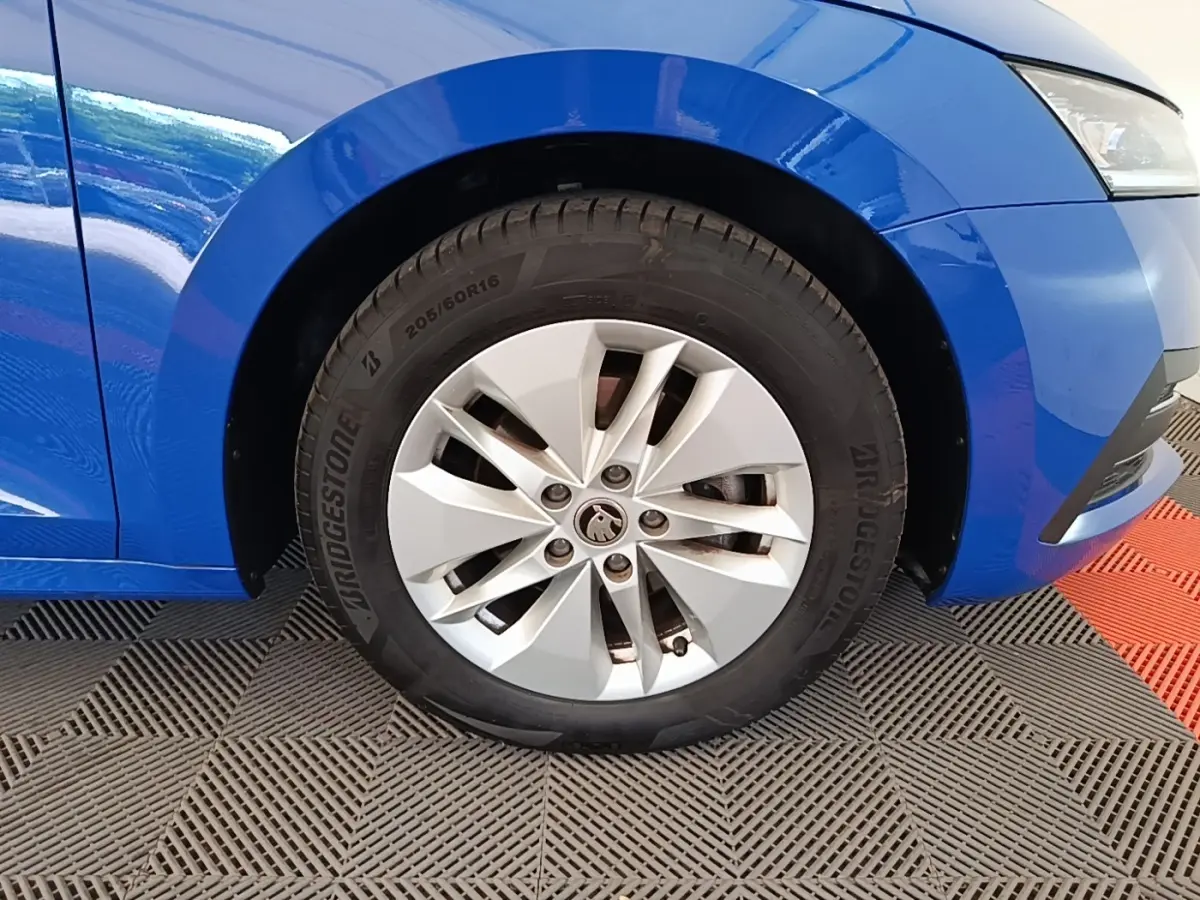 Gros plan sur la roue avant droite d’une Skoda Octavia bleue 2024 avec jante argentée et pneu Bridgestone.