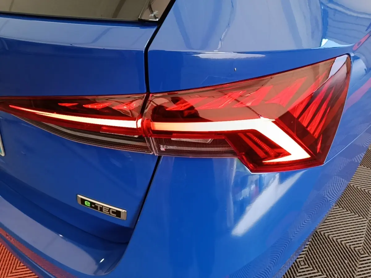Gros plan sur le feu arrière droit rouge et le logo e-TEC d'une Skoda Octavia bleue 2024 vue de l'arrière.