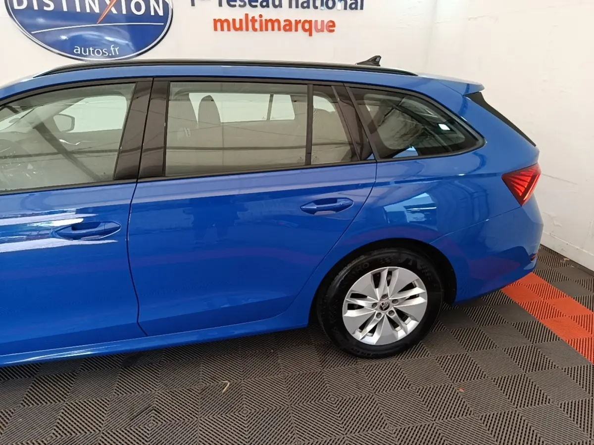 Vue latérale droite d'une Skoda Octavia break 2024 bleu vif avec jantes argentées et vitres teintées.
