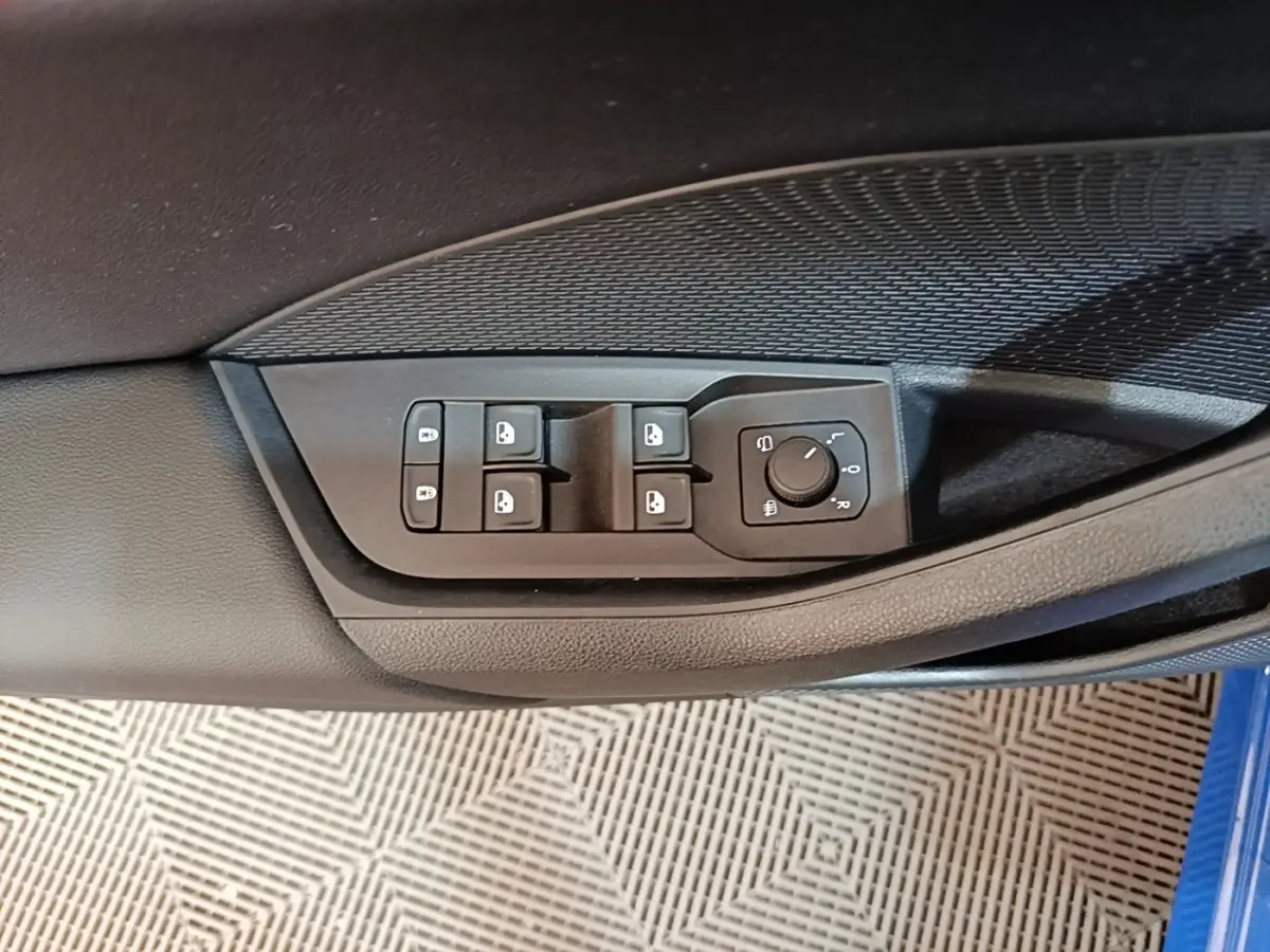 Commande des vitres et réglage des rétroviseurs sur la porte côté conducteur d'une Skoda Octavia bleue.