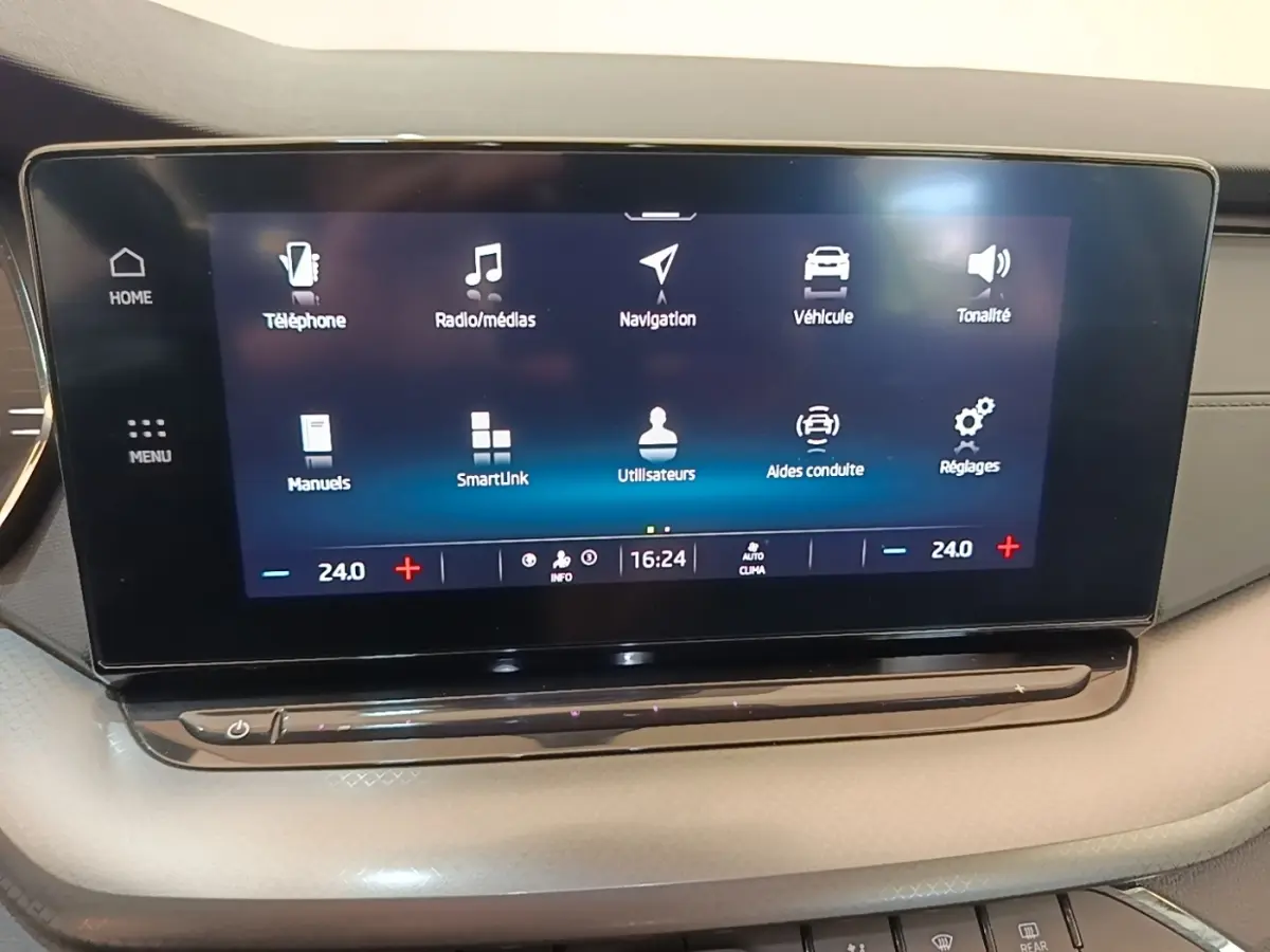 Écran tactile central de la Skoda Octavia 2024 affichant les menus de navigation et climatisation, intérieur beige.