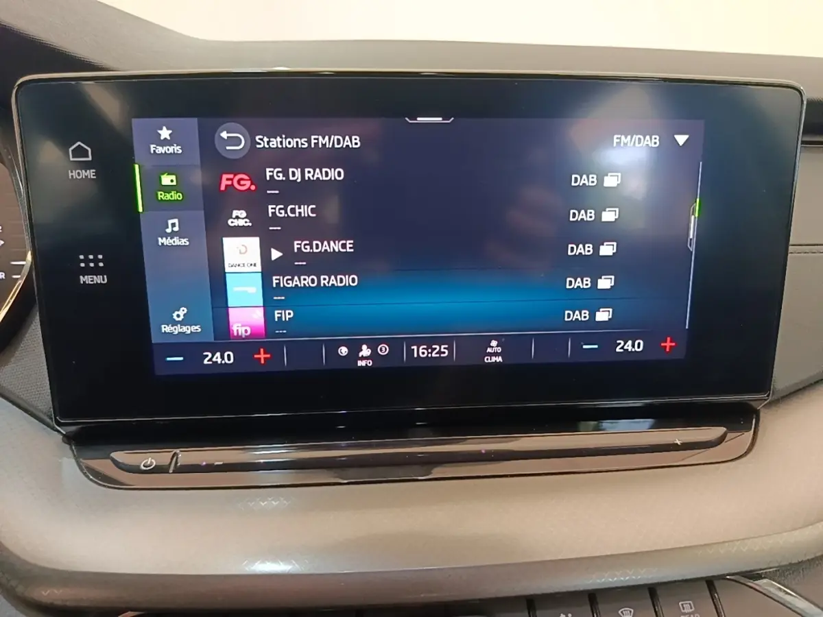 Écran tactile central de la Skoda Octavia 2024 affichant les stations radio FM/DAB, avec commandes climatisation en dessous.