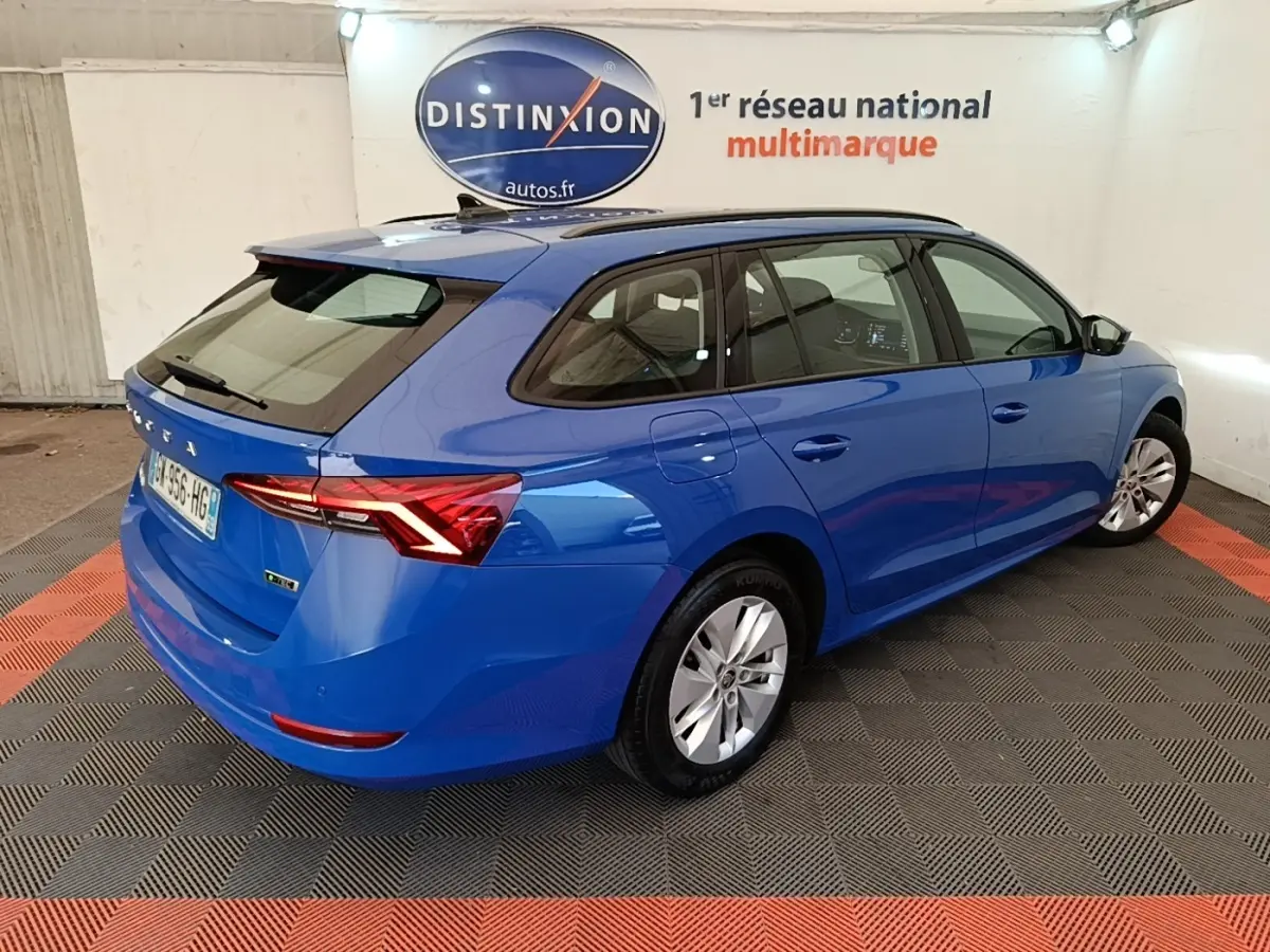 Vue 3/4 arrière droite d'une Skoda Octavia 2024 hybride bleue avec toit noir et feux arrière LED distinctifs.