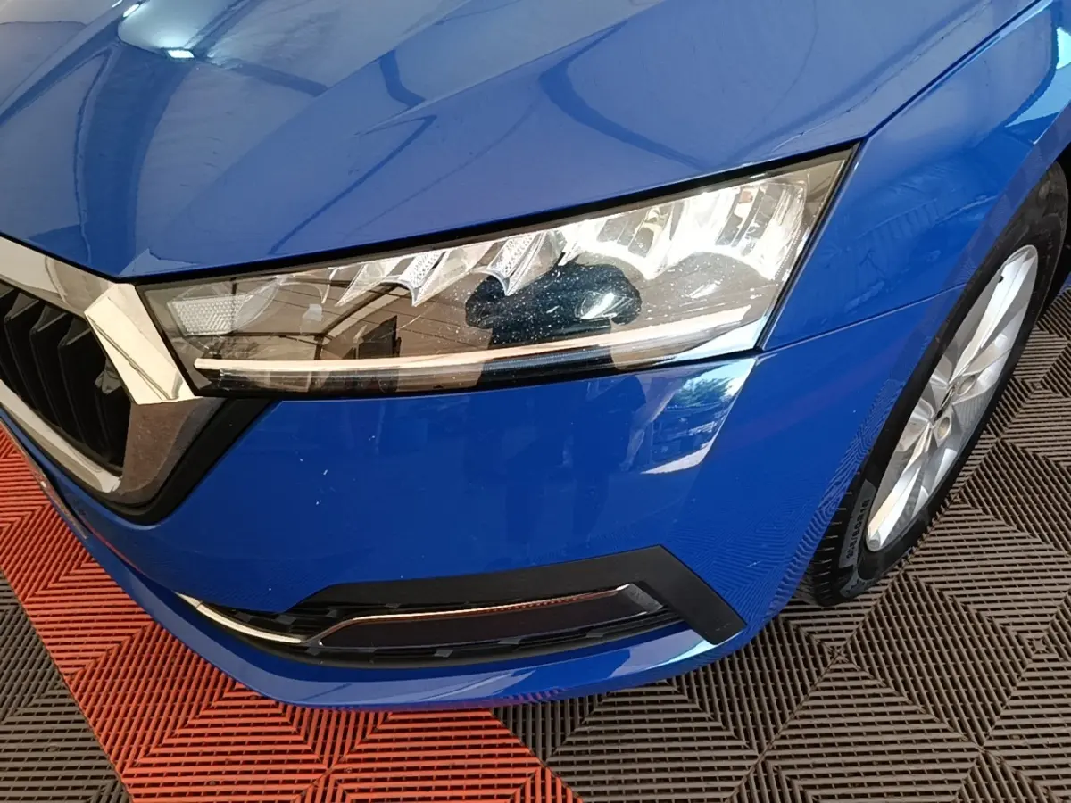 Gros plan sur l'avant droit bleu vif d'une Skoda Octavia 2024, mettant en valeur le phare LED et la calandre chromée.