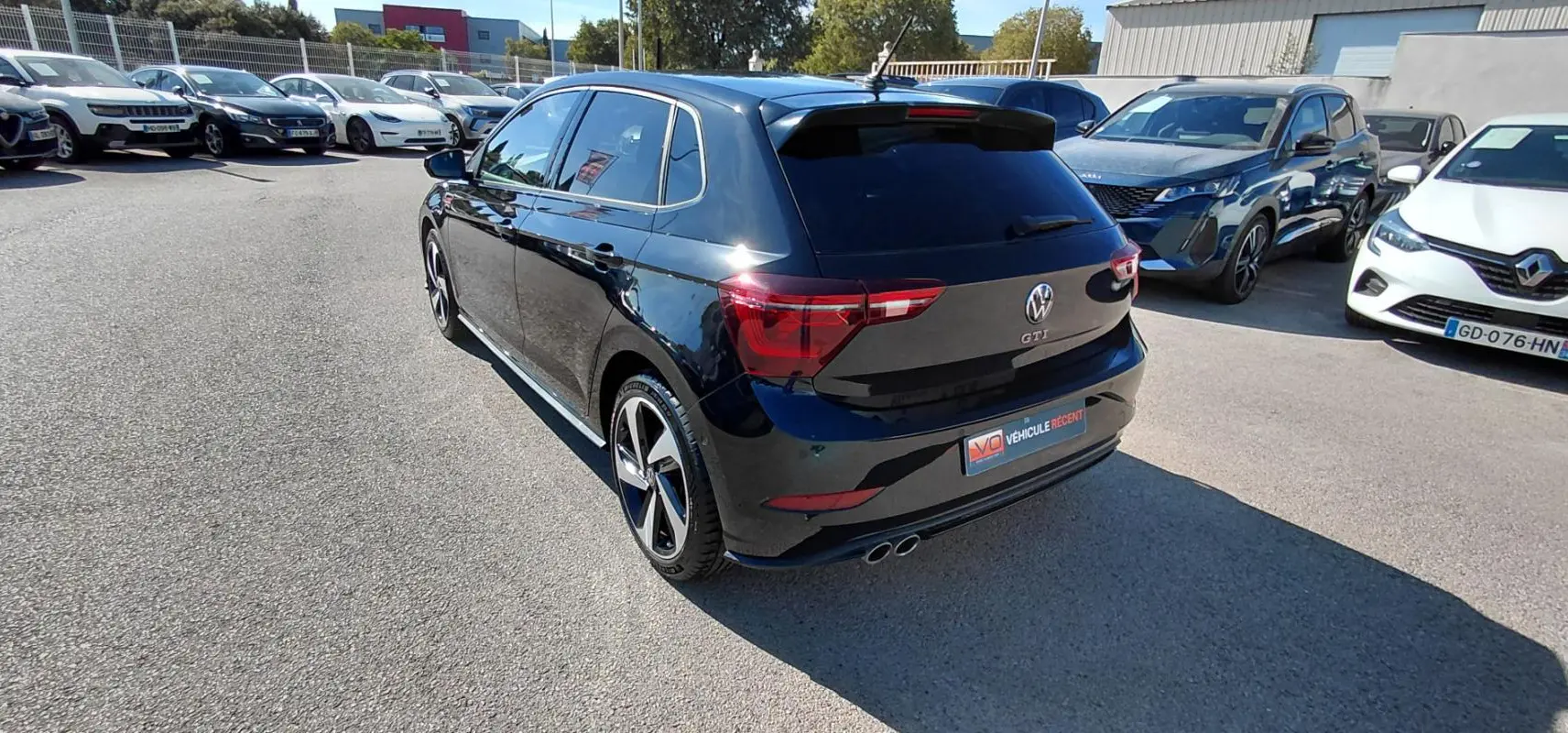 Volkswagen Polo GTI noir vue 3/4 arrière droit, jantes alliage 17 pouces et double sortie d’échappement chrome.