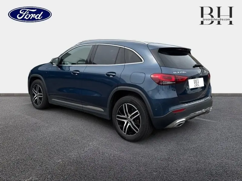 Vue 3/4 arrière droite d'un Mercedes GLA 250 e bleu denim métallisé avec jantes alliage et feux arrière LED.