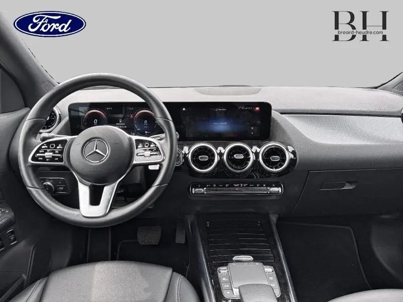 Intérieur noir du Mercedes GLA 250 e 2020 vu de face, avec tableau de bord numérique et volant multifonction cuir.