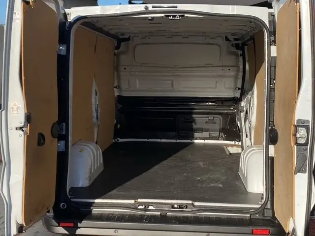 Vue arrière ouverte du Renault Trafic Fourgon blanc 2023, montrant l'intérieur avec kit bois sur les parois.