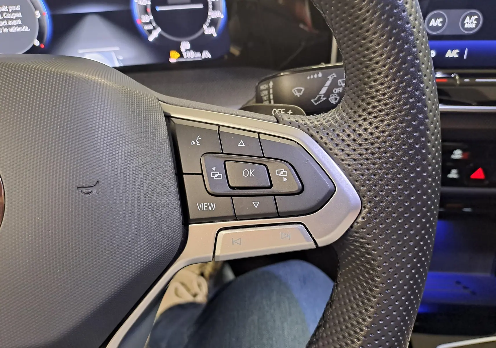 Gros plan sur les commandes au volant en cuir perforé noir de la Volkswagen Golf 2.0 TDI 150 DSG7 R Line 2024.