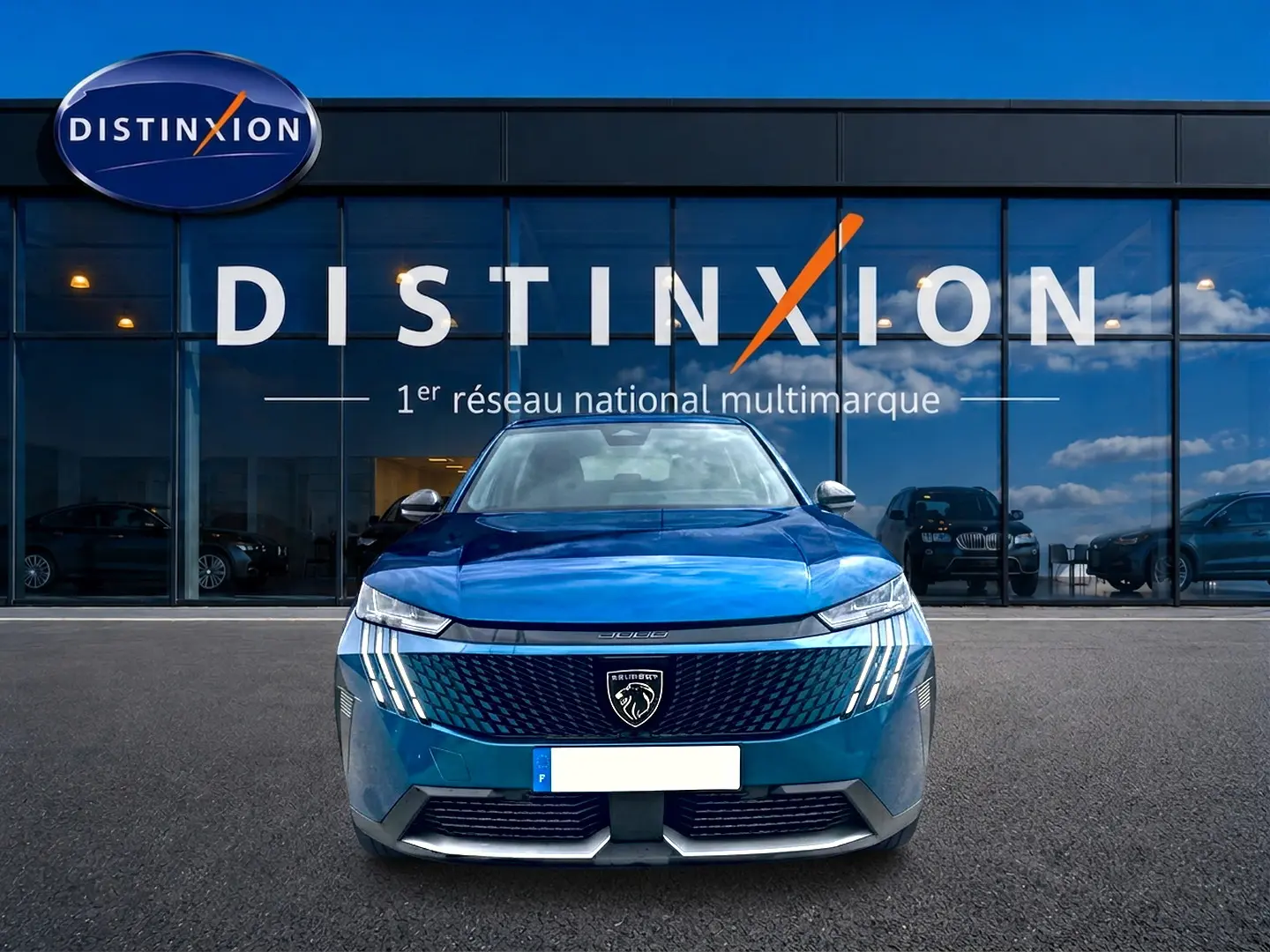Vue frontale d'un Peugeot 3008 2025 bleu obsession avec calandre distinctive et phares LED verticaux allumés.