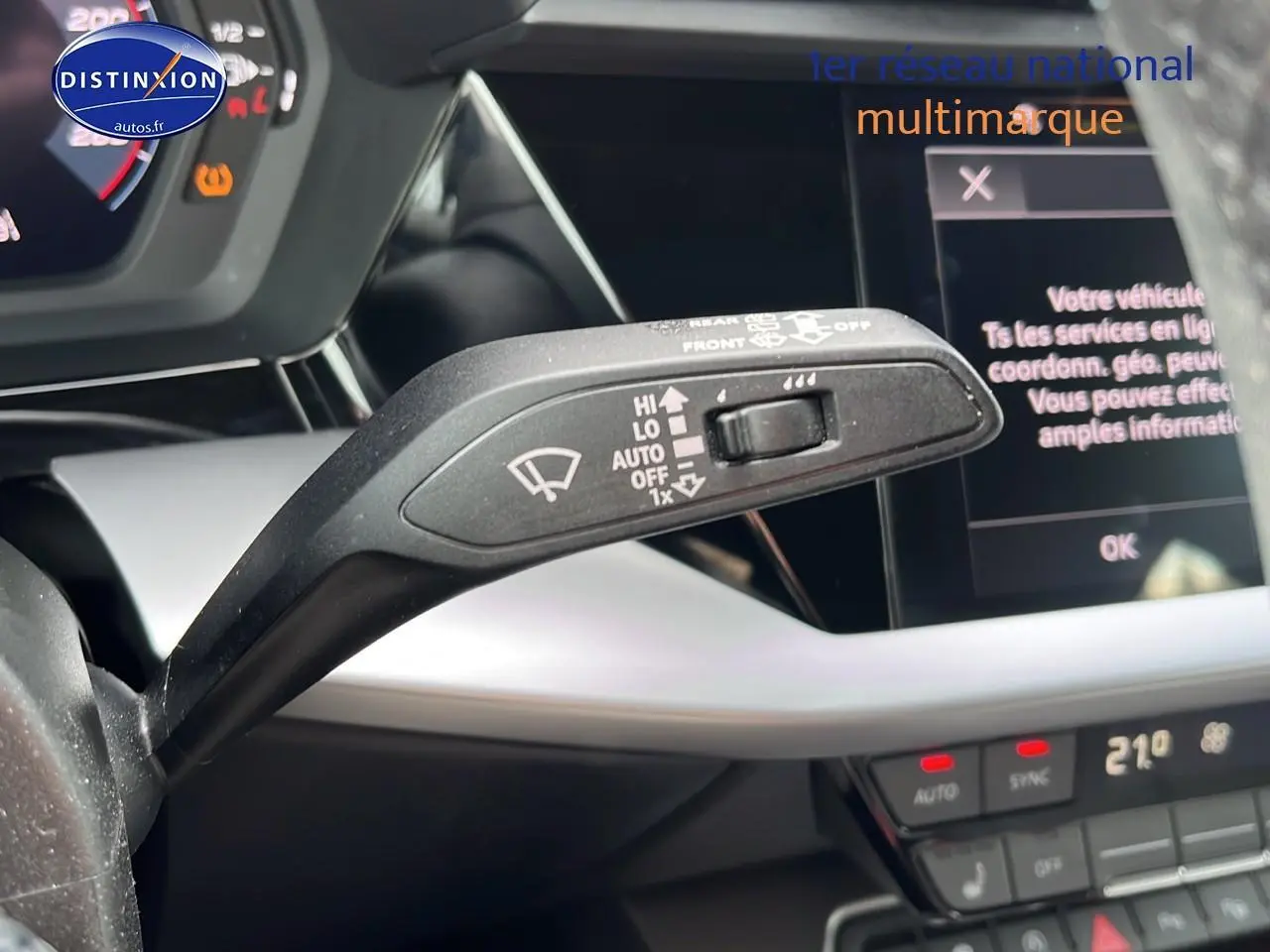 Le levier de commande des essuie-glaces en gros plan dans l'habitacle gris et noir de l'Audi A3 Sportback 2023.