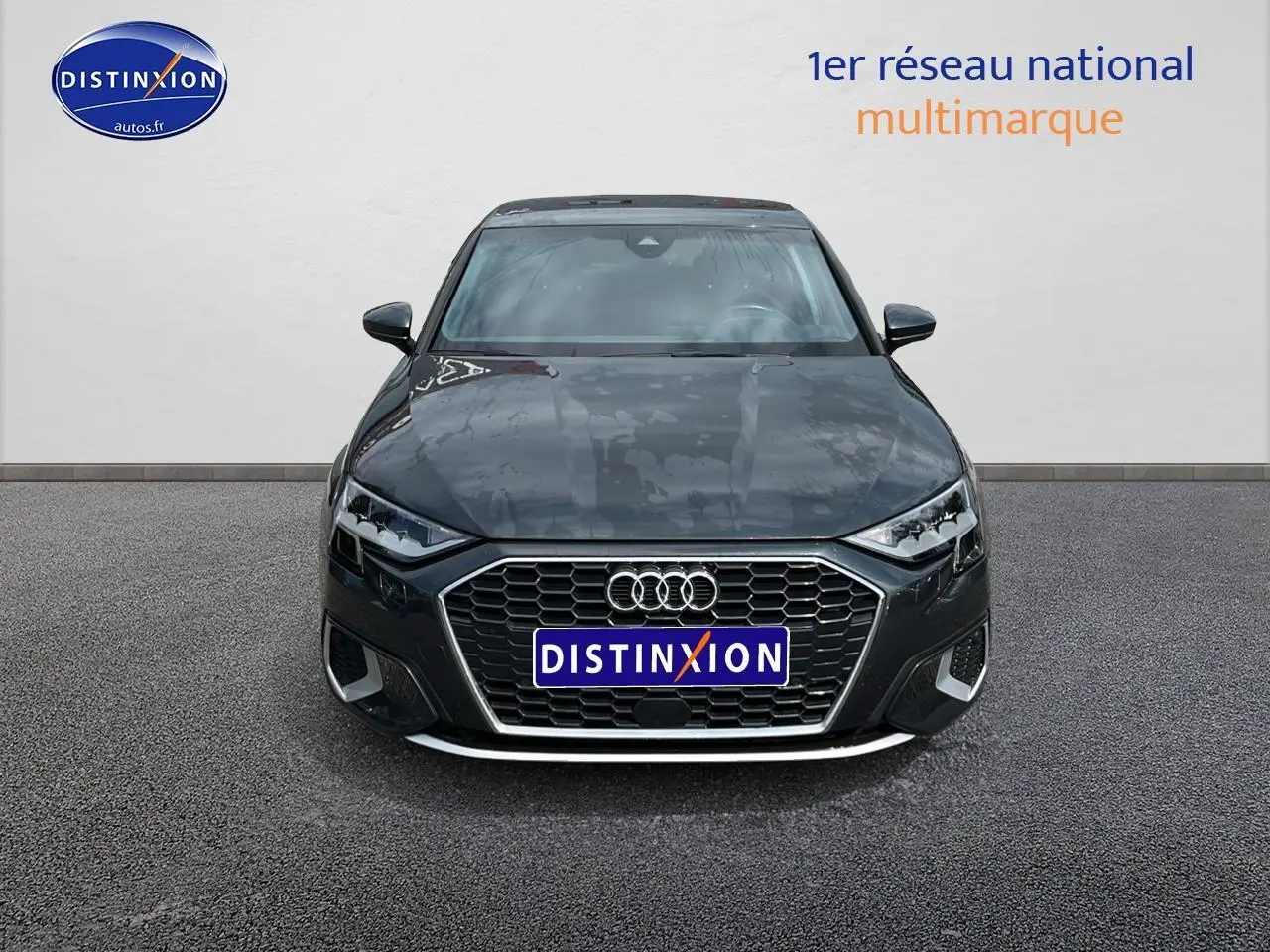 Vue frontale d'une Audi A3 Sportback gris Manhattan avec calandre hexagonale et phares LED distinctifs.