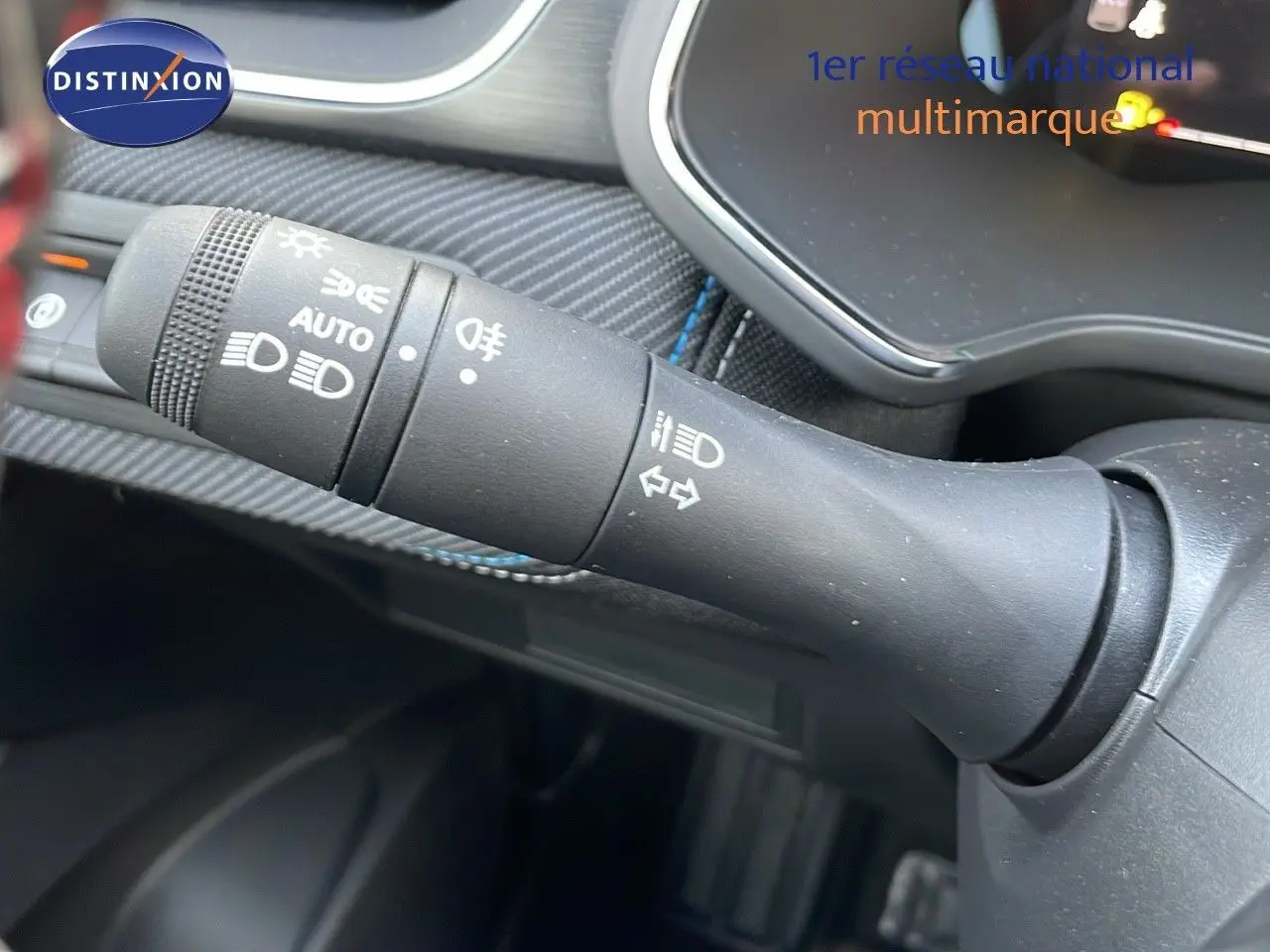 Gros plan sur la commande des feux et clignotants dans l'habitacle du Renault Captur E-Tech hybride noir étoile.